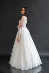 Beautiful bride in a magnificent white wedding dress of tulle with corset lacing and long beauty hair