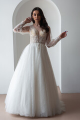 Beautiful bride posing in wedding dress in a white photo Studio.