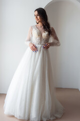 Beautiful bride posing in wedding dress in a white photo Studio.