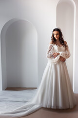 Fototapeta premium Full length portrait of young beautiful woman wearing white wedding dress. Elegant bride standing and posing