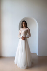 Fototapeta premium Beautiful woman wearing in luxurious long wedding dress. Concept of wedding hairstyle, makeup and accessories.