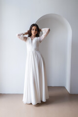Fototapeta premium Beautiful woman wearing in luxurious long wedding dress. Concept of wedding hairstyle, makeup and accessories.