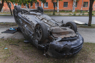 Car accident. An overturned car lying upside down on the street after an accident. Car lands on...