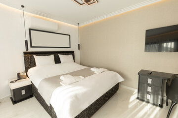 Interior of a luxury double bed hotel bedroom with black and white furniture