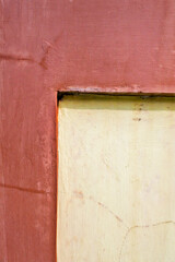 angled corner of the wall which is painted in two different colors, namely yellow and reddish brown