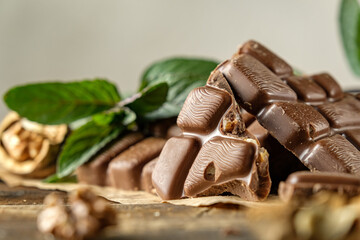 scary photo of chocolate, ugly photo of milk chocolate, slices of chocolate on white background, mint and raspberry leaves on white background, photo of chocolate for magazine with space for text
