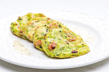 still life of zucchini cakes with bacon