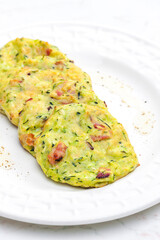 still life of zucchini cakes with bacon