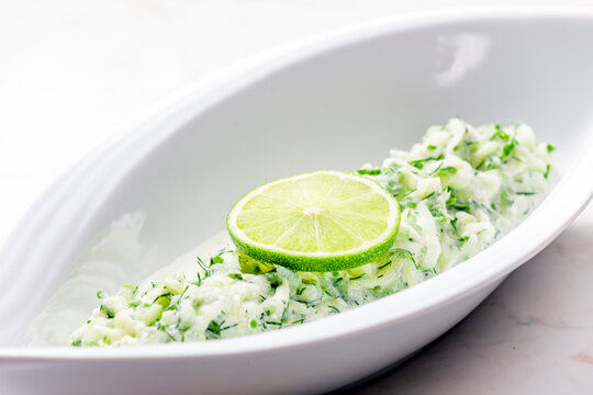 tzaziki salad with lime in white bowl