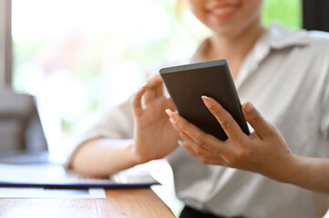 Female using a cellphone, chatting, scrolling on social media or shopping application.