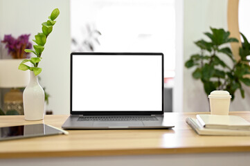 Minimal bright workspace with notebook laptop, tablet and decor plants on wood table.