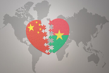 puzzle heart with the national flag of china and burkina faso on a world map background. Concept.