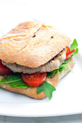 homemade turkey burger with cherry tomatoes and arugula in ciabatta