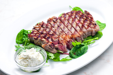 beef steak with garlic dip and spinach and ruccola leaves