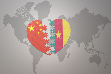 puzzle heart with the national flag of china and cameroon on a world map background. Concept.