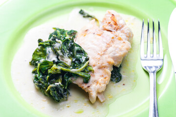 poultry breast with spinach leaves and sauce