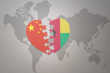 puzzle heart with the national flag of china and guinea bissau on a world map background. Concept.