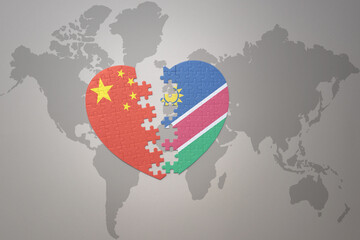 puzzle heart with the national flag of china and namibia on a world map background. Concept.