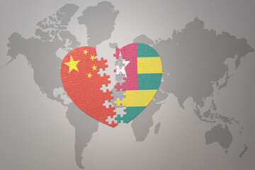 puzzle heart with the national flag of china and togo on a world map background. Concept.