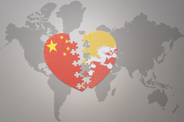 puzzle heart with the national flag of china and bhutan on a world map background. Concept.