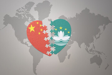 puzzle heart with the national flag of china and Macau on a world map background. Concept.