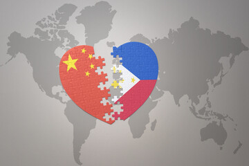 puzzle heart with the national flag of china and philippines on a world map background. Concept.