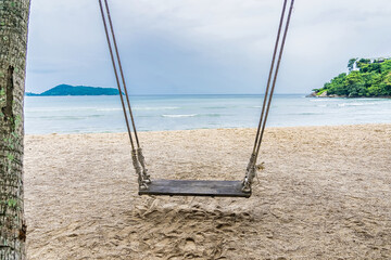 Wood swing at the beach and sand background.