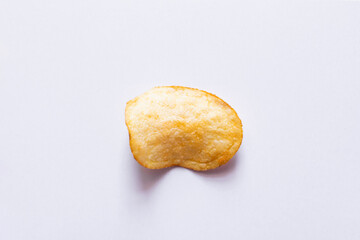 top view of single fried and salty potato chip on white