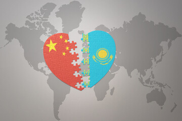 puzzle heart with the national flag of china and kazakhstan on a world map background. Concept.