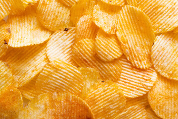 bunch of wavy and salty potato chips, top view