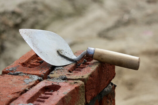 old rusty Masonry Trowel Mason tool on bricks work under construction