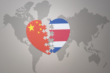 puzzle heart with the national flag of china and costa rica on a world map background. Concept.