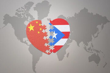 puzzle heart with the national flag of china and puerto rico on a world map background. Concept.