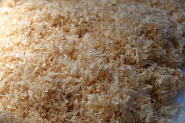 A pile of wood shavings background. Textured wood shavings background. Biodegradable wood shavings for exotic pet.  