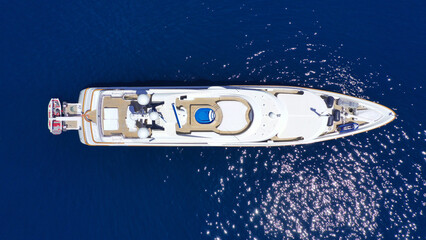 Aerial drone photo of large yacht with wooden deck anchored in Aegean island deep blue sea