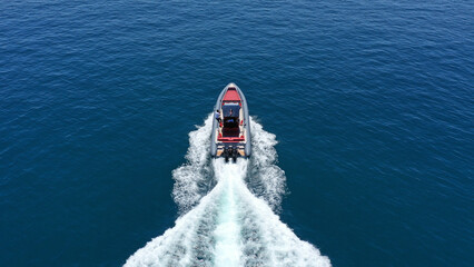 Aerial drone photo of inflatable rigid power boat cruising in high speed in Aegean deep blue sea...
