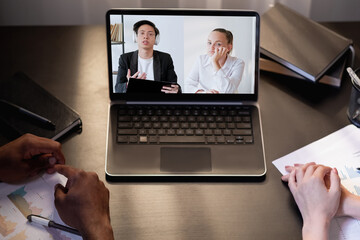 Fototapeta na wymiar Video interview. Remote meeting. International teleconference. Tired diverse business colleagues watching boring presentation on laptop screen in virtual office.