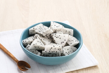 A bowl of fresh dragon fruit served on bowl on wooden background. Breakfast fruit in the morning. Selected focus image
