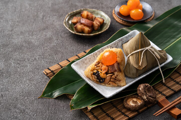Zongzi, rice dumpling for Dragon Boat Festival on dark gray table background with ingredient.