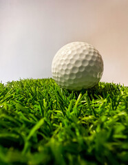 Macro of white golf ball on green artificial grass