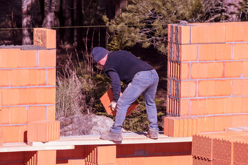 The builder lays bricks on the wall. Bricklaying. Bricklayer builder, private master. Construction of a cottage, a country house.