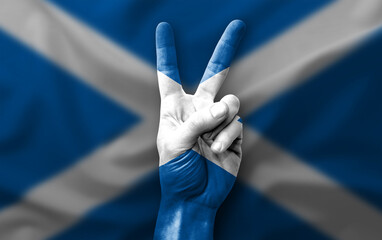 Hand making the V victory sign with flag of scotland