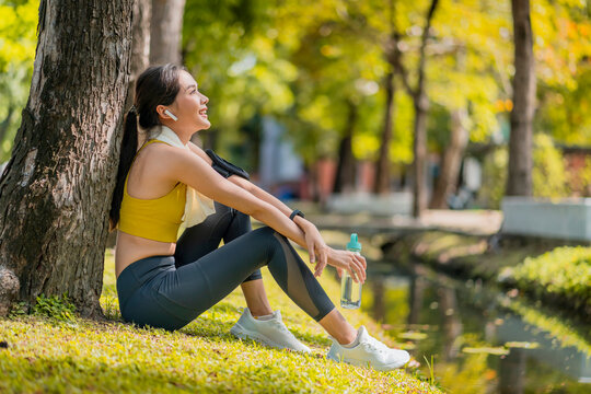 Relax Casual Asian Female Sportwoman Break Time After Finish Morning Run Exercise Healthy Lifestyle ,asian Female Relax Cooling Down After Run Training Under The Tree Near Water In The Park