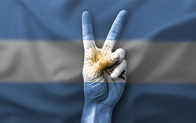 Hand making the V victory sign with flag of argentina