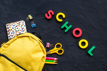 School backpack with school items and students equipment, top view