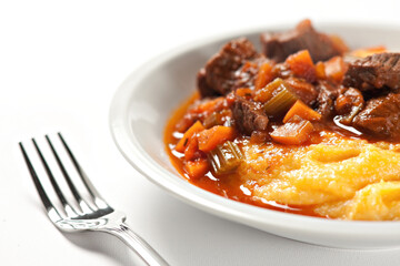 Polenta and beef stew on a plate. High quality photo.
