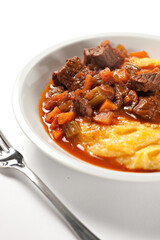Polenta and beef stew on a plate. High quality photo.