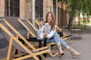 blogger with a mobile phone on the summer terrace