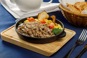 Beef Stroganoff on wooden board in restaurant