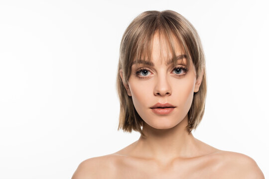 young woman with bangs hairstyle and bare shoulders looking at camera isolated on white